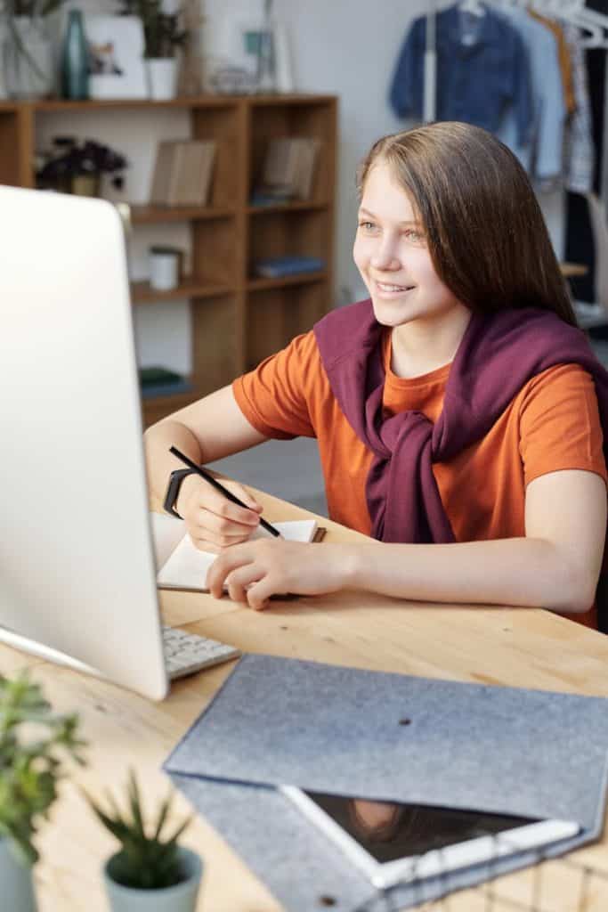 Woman in Orange Shirt taking online lessons